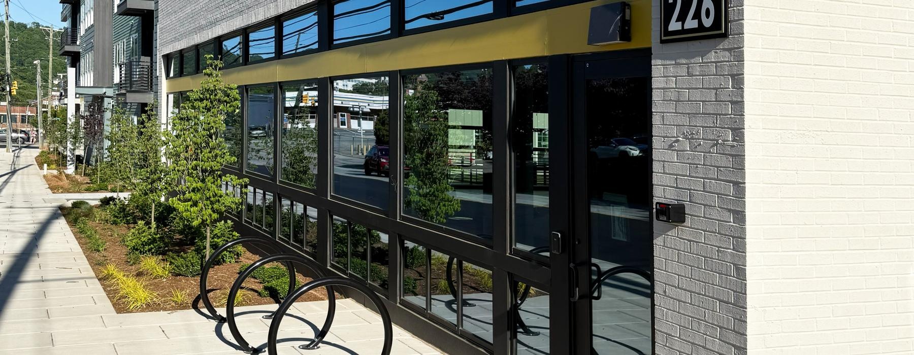 a building with a glass front and bike recepticles