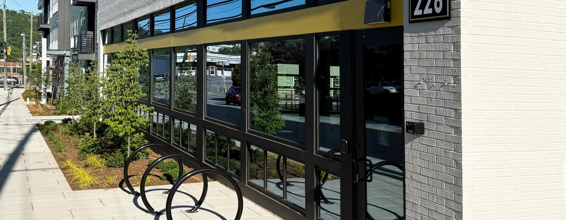 a building with a glass front and bike recepticles